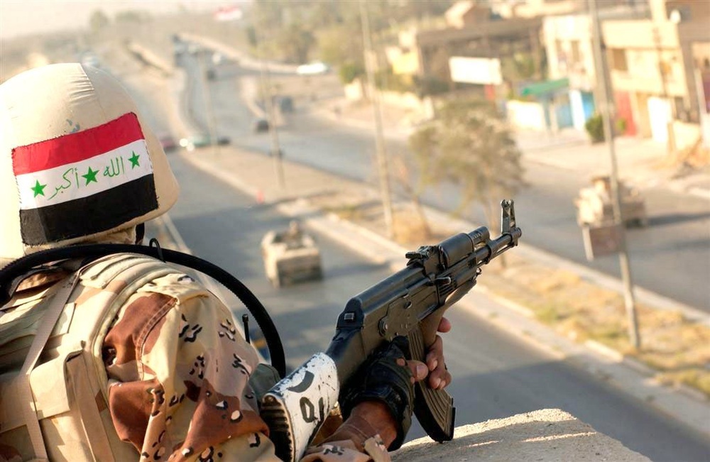 An Iraqi Soldier displays his country's flag with pride by wearing i