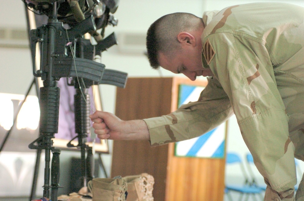 Maj. Robert Petit grips the ID tags of Chief Warrant Officer 4 Keith R. Mar