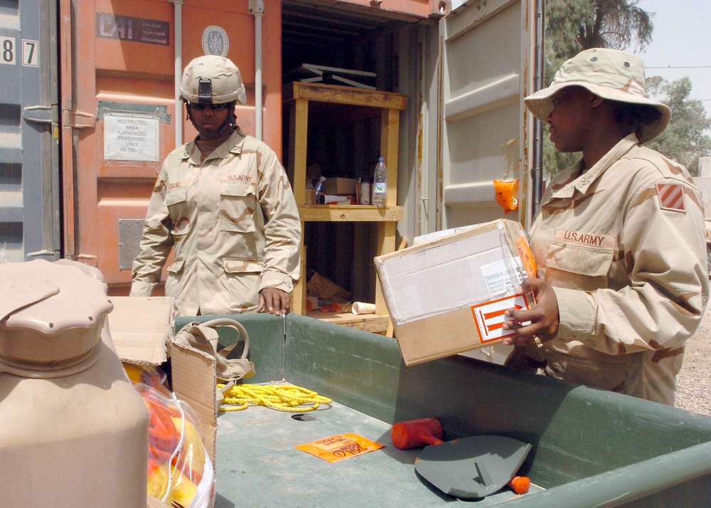 PFC Cogdell and PFC Robins unload supplies to be stored in a Conex box
