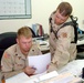 SPC Mitchell and PFC George go over supply forms in the battalion supply of