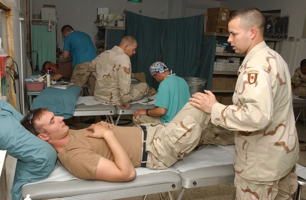 Staff Sgt. Thomas Leach, checks out the knee of Sgt. Daniel J. S