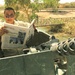 PFC Curbow reads a newspaper while he waits in the turret of his truck