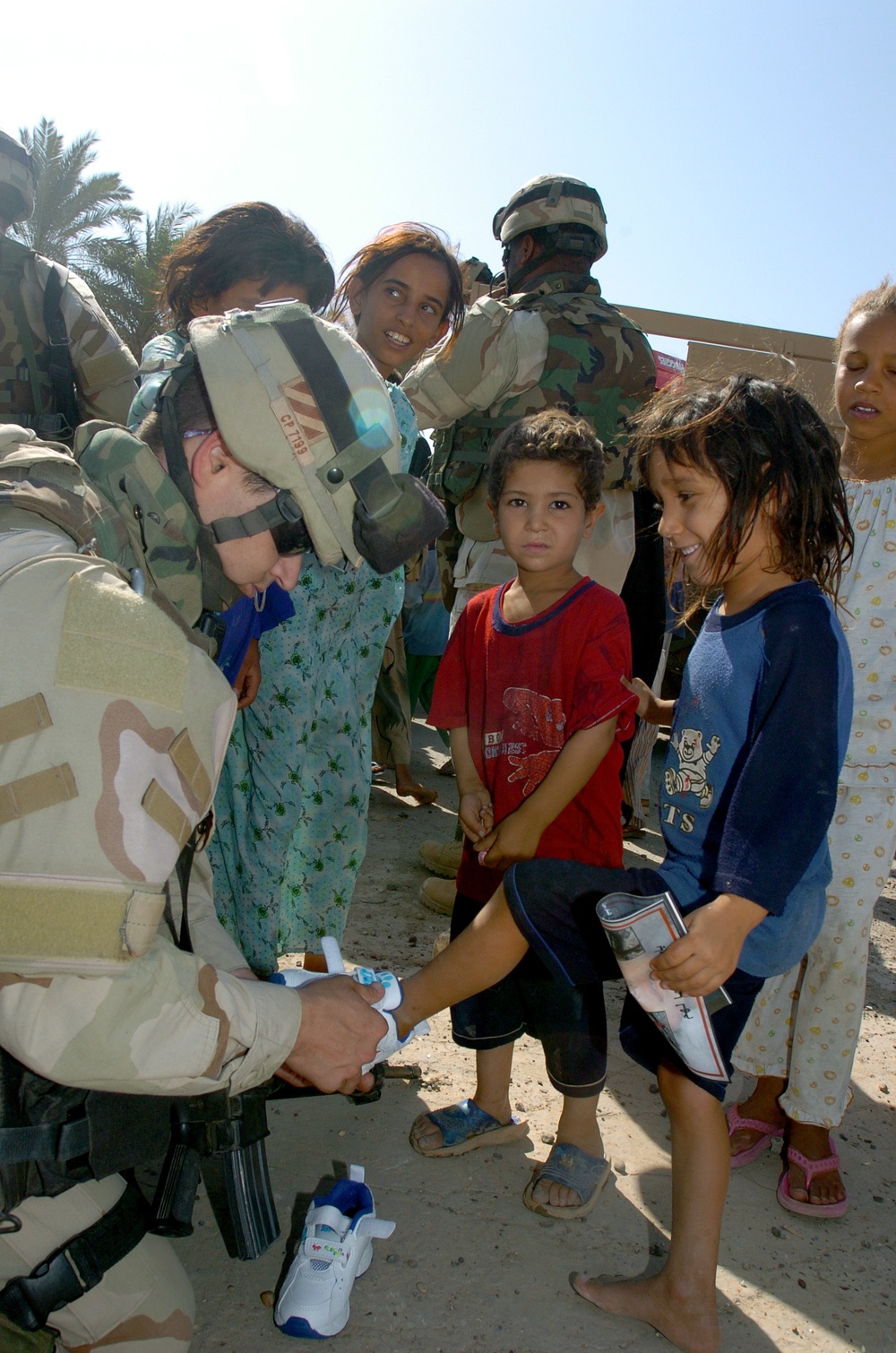 CPT Price helps a girl into a new pair of shoes