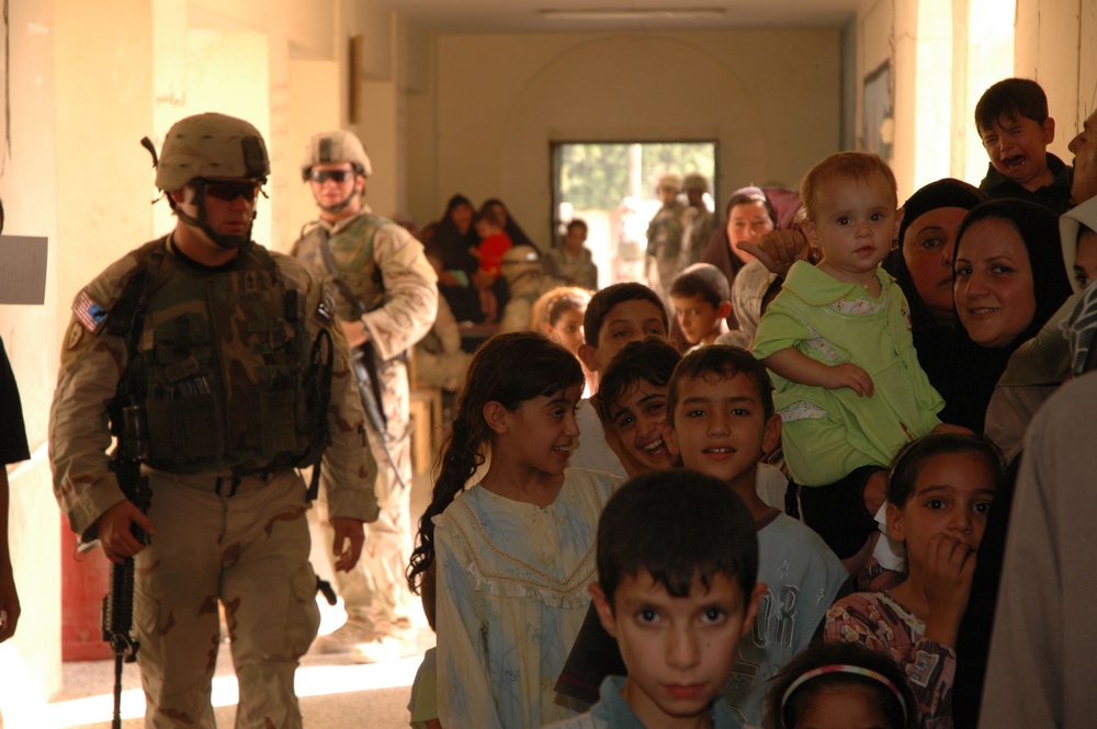 Soldiers Assisting Iraqi families during a medical screening