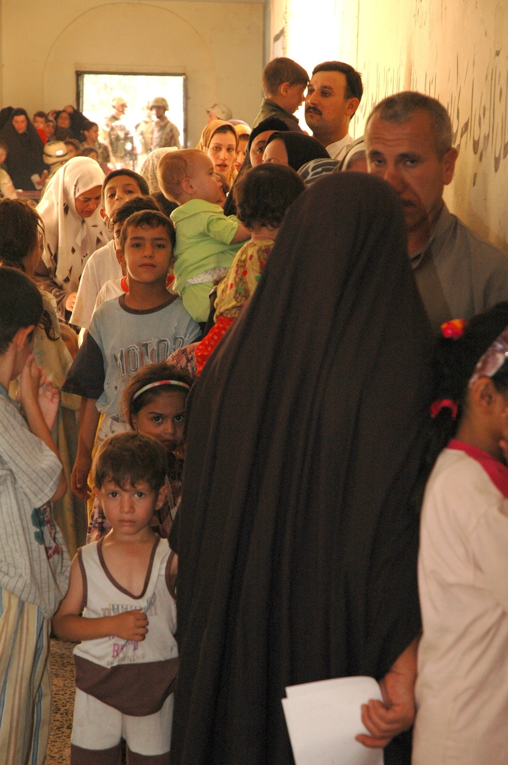 Iraqi families line up at a schoolhouse