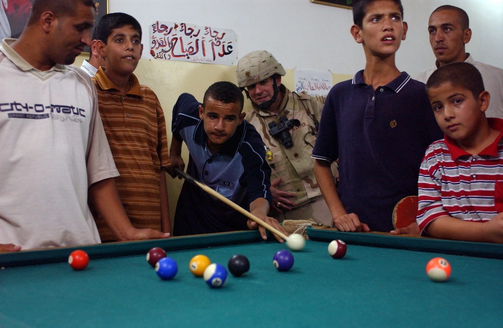 Maj. Neil Harper enjoys a game of pool with children