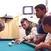 SSG Kenneth Stephens plays a game of pool with Iraqi youth