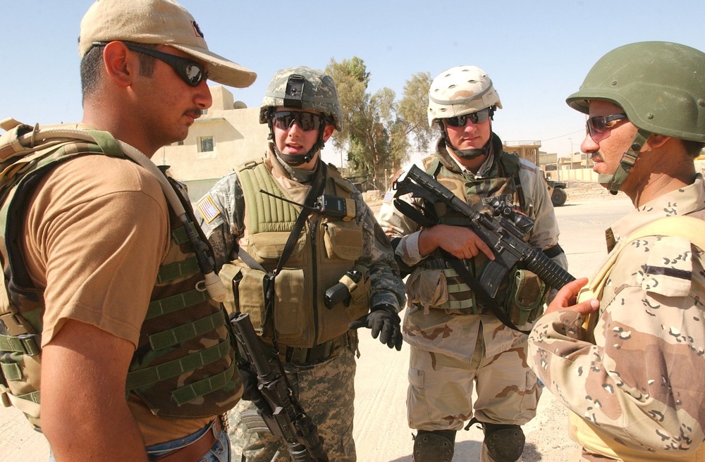 Pennsylvania National Guardsman talk to an Iraqi soldier