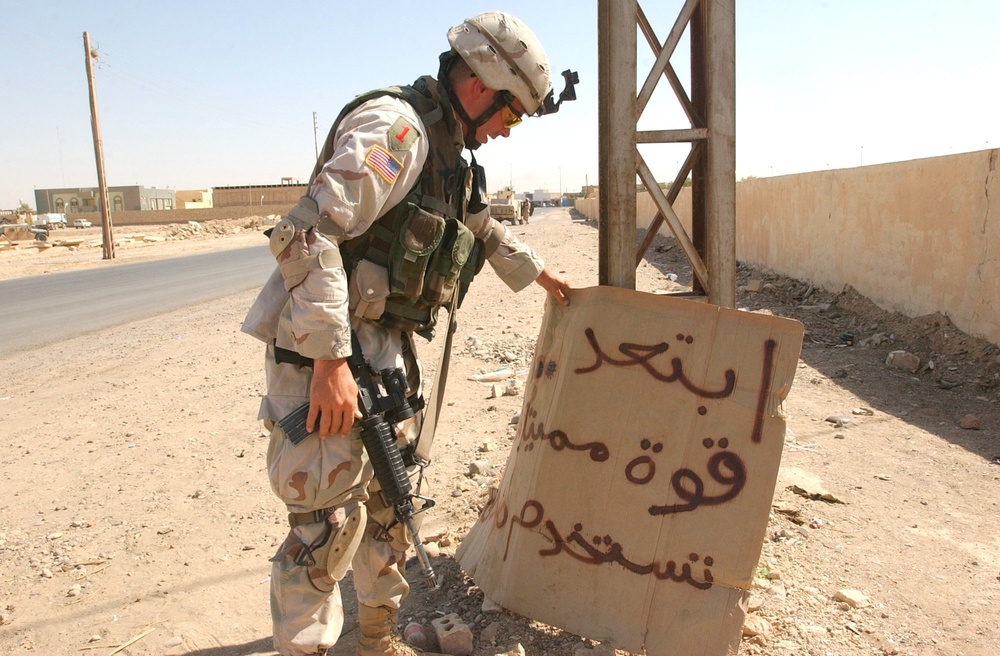 Pennsylvania National Guardsman  displays a sign warning the presence of Co