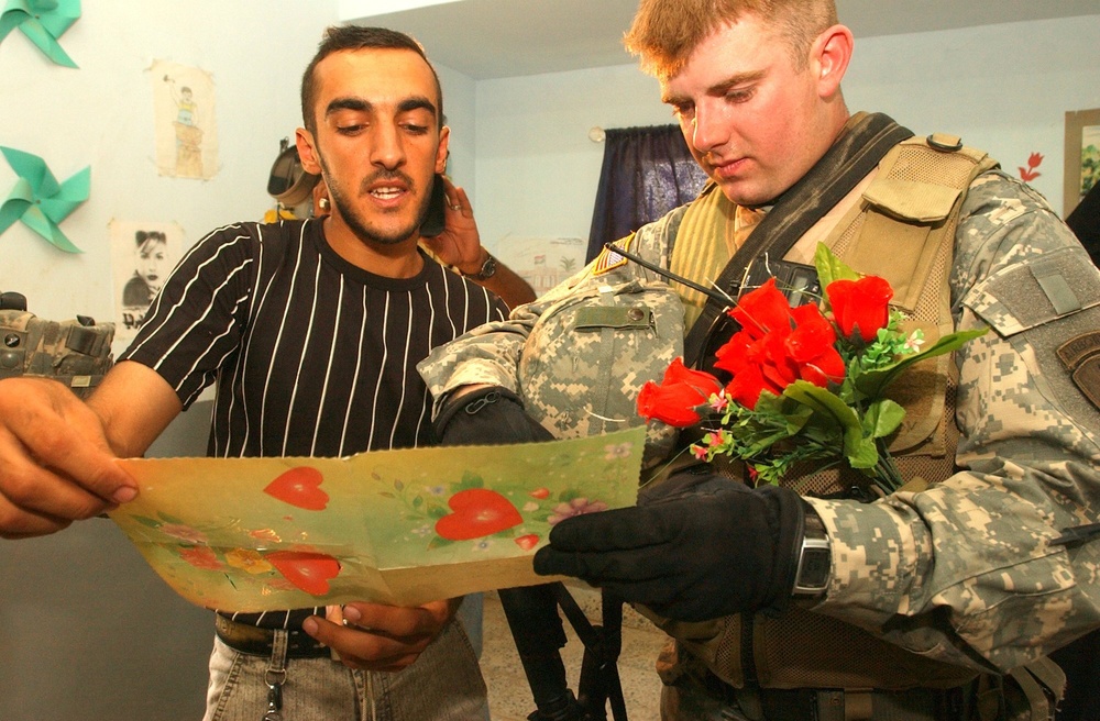 Spc. Richardson listens as Simon translates a card made for the Soldiers by