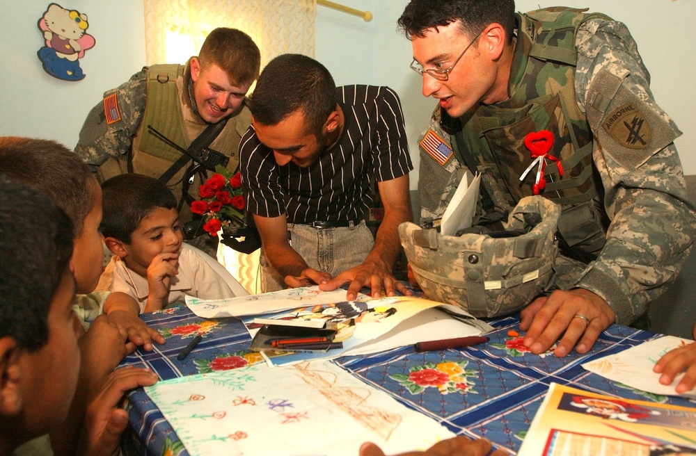 CPT Ortega and SPC Richardson look at drawings by children of the Tikrit Di