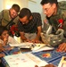 CPT Ortega and SPC Richardson look at drawings by children of the Tikrit Di