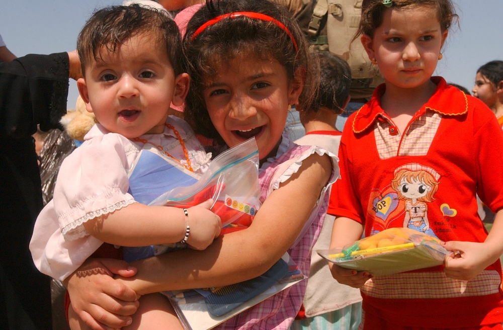 Young Iraqi girl holds baby boy