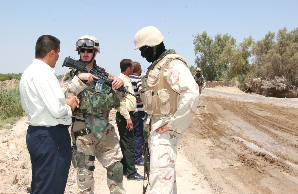 1LT Krueger and his translator talk with a local leader