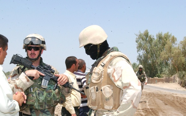 1LT Krueger and his translator talk with a local leader