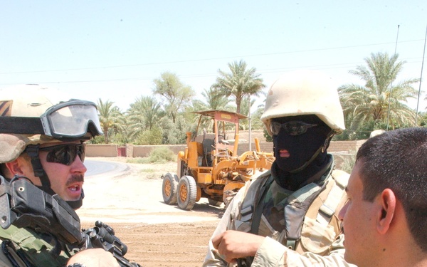 1LT Krueger and his translator talk with a local leader