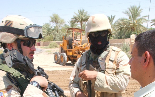 1LT Krueger and his translator talk with a local leader