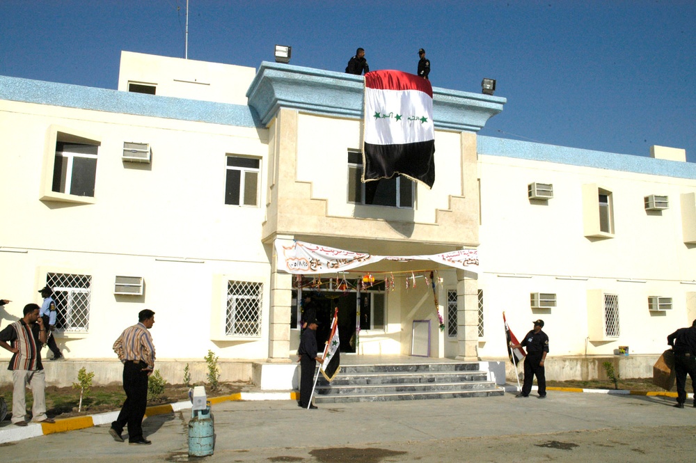 Members of the Iraqi Highway Patrol unfurl the national flag the new Iraqi