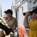 a Sailor gets a closer look at a passing ship with binoculars