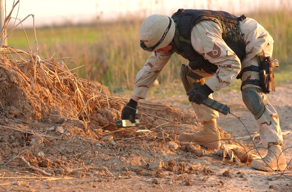 Tech Sgt. Stillings places C-4 blocks of explosives on an unexploded IED