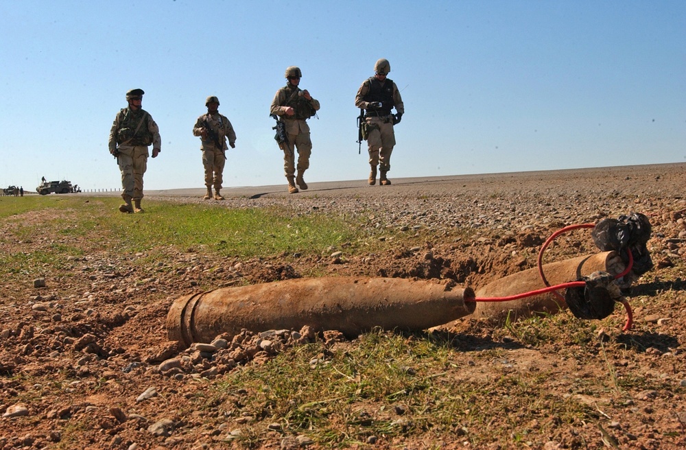 Soldiers advance on a disarmed improvised explosive device.
