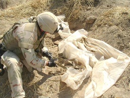 a Soldier digs up a weapon cache