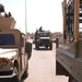 Iraqi army cargo trucks pass by a gun truck
