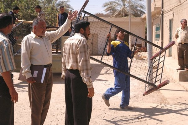 A worker from Balad General Hospital moves a bed