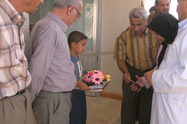 Mayor og Balad, Fauzi Ahmed Khalaf hands scissors to an Iraqi doctor