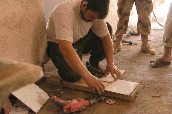 An Iraqi worker prepares a tile