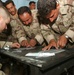 Spc. Italiano watches as Iraqi Soldiers practice sticking IVs into simulate