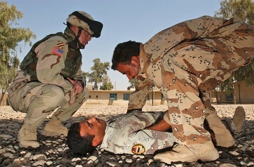 Spc. Hardwick watches as an Iraqi soldier practices assessing a casualty