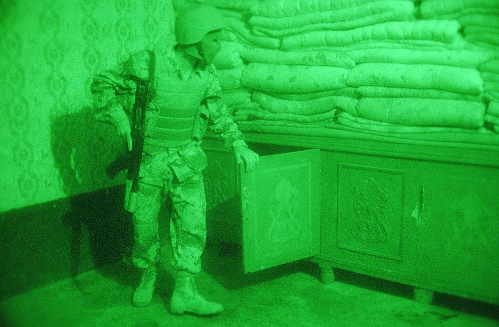 An Iraqi Soldier searches a room