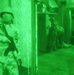 An Iraqi Soldiers atnad guard while other Soldiers search a closet