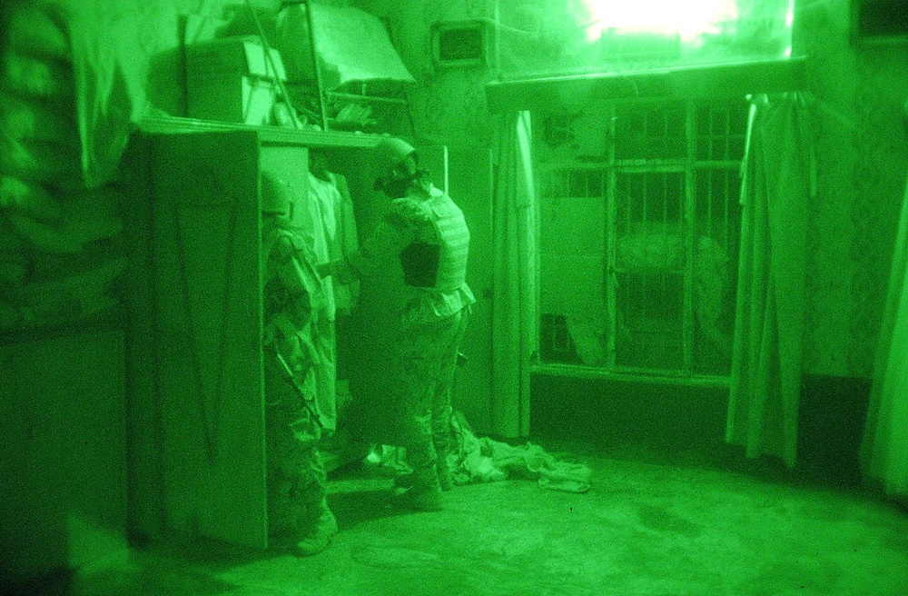 Iraqi Soldiers search through a closet in a house