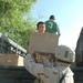 Children rush to help Soldiers unload boxes packed with school supplies