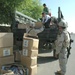 Children rush to help Soldiers unload boxes packed with school supplies