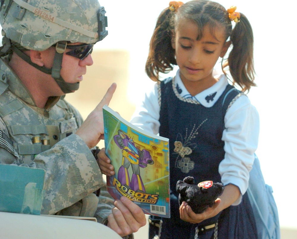 Spc. Chris Greninger gves a gift to a young girl