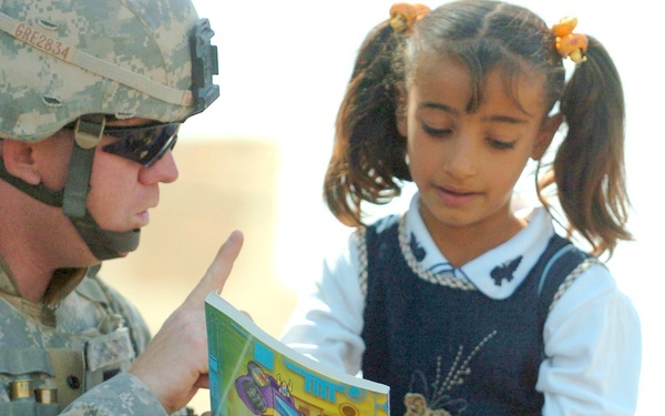 Spc. Chris Greninger gves a gift to a young girl