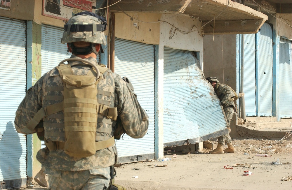 Sgt. Brooks peels back an unsecured door of a business in Tall Afar