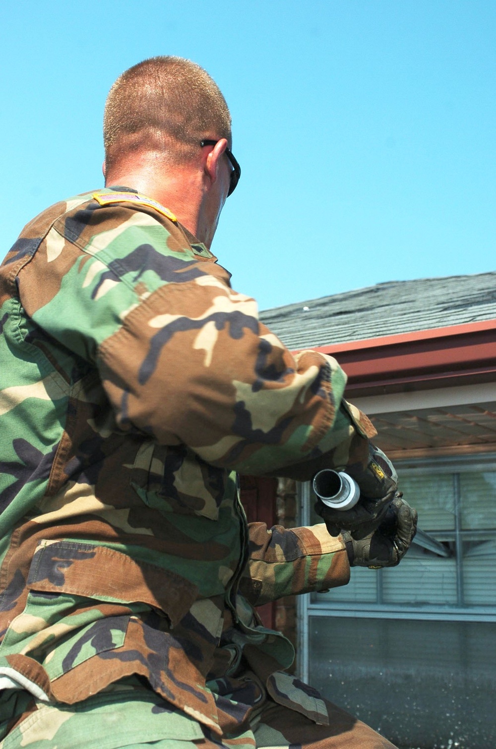 Soldier uses a pole to break through a window