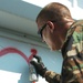 A Soldier paints a house that has been searched