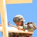 A US Soldier constructs the frame of a guard post