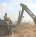 A US Soldier uses a backhoe during construction of a fueling point