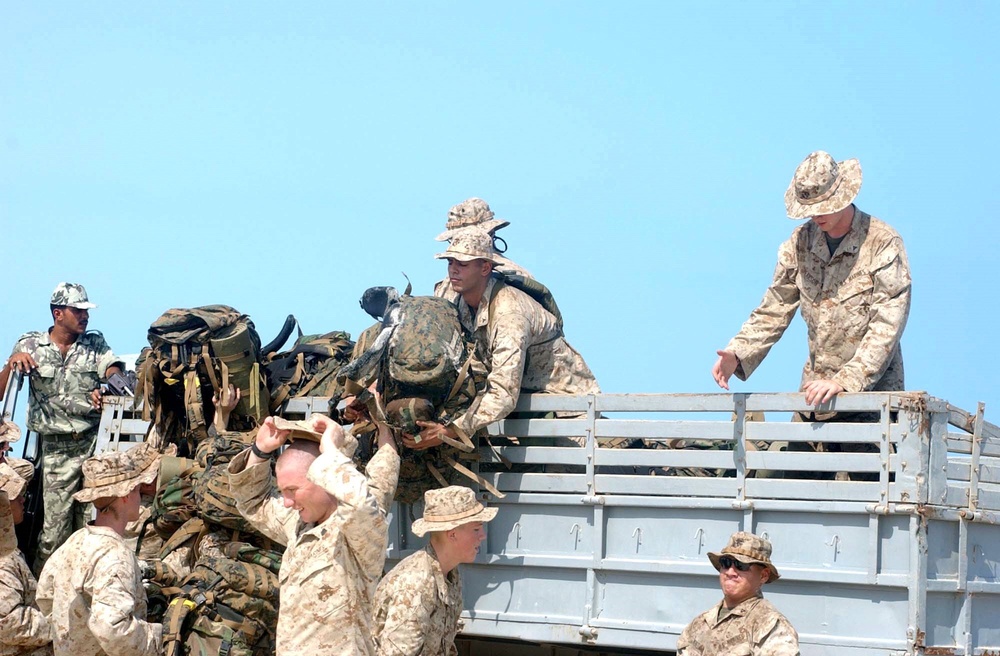 U.S. Marines load their excess gear unto a truck