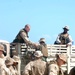 U.S. Marines load their excess gear unto a truck