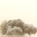 A cloud of smoke and debris rise from the impact of an MLRS rocket