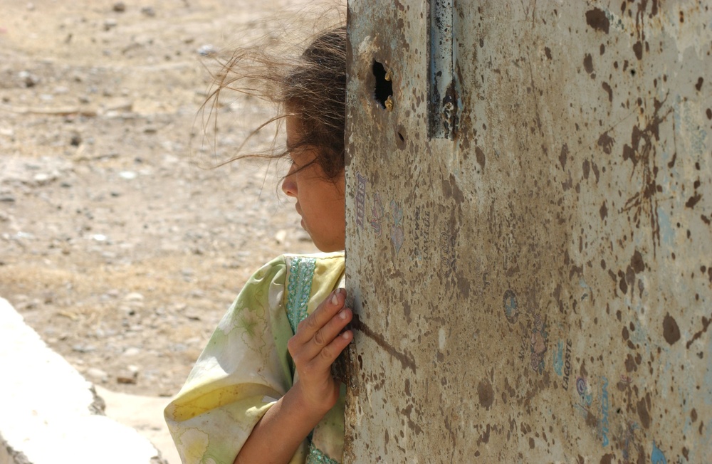 A Young Girl Watches as Soldiers Enter a School That She Has Been Living in