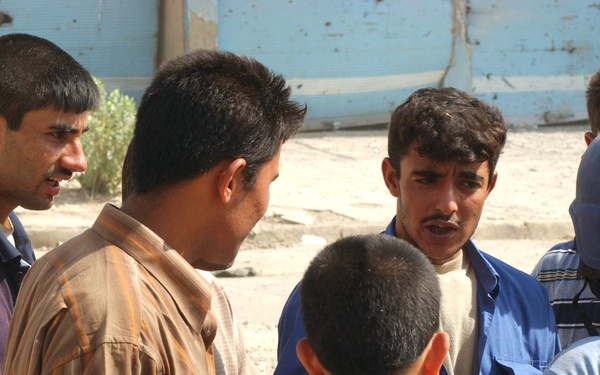 Residents of the war-torn city of Tall Afar, Iraq, crowd around Sindebad Ah