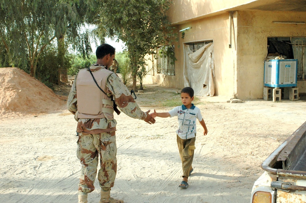An Iraq Soldier greets a young boy